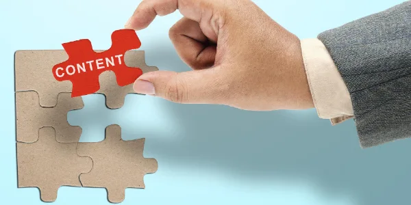 Business hand showing content text on a piece of jigsaw puzzle